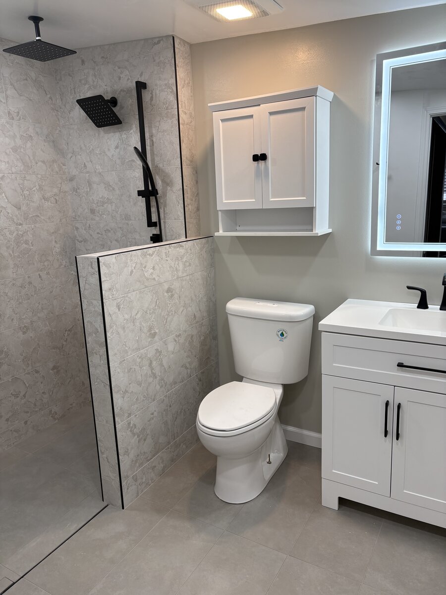 Modern bathroom walk-in shower with marble tile and matte black rain showerhead
